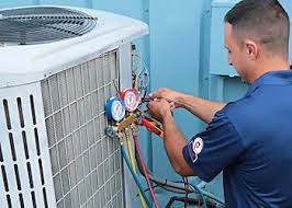 Technician checking pressure gauges connected to an outdoor condenser